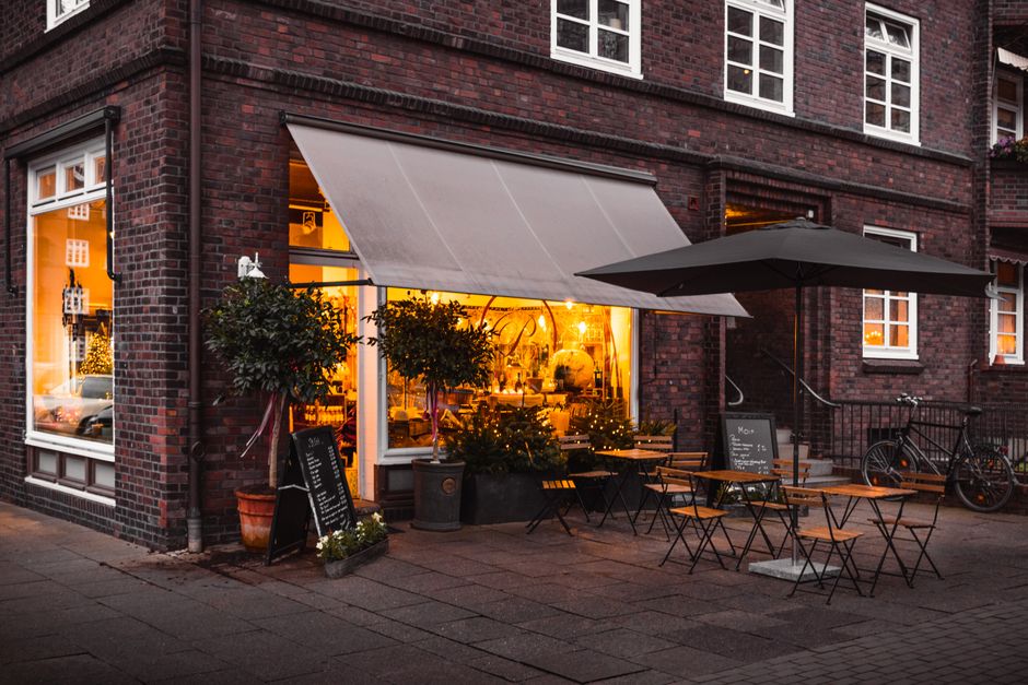 exterior view of a cozy coffee shop with greenery and sidewalk seating